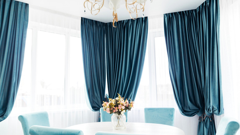 bright blue dining area with blue velvet curtains
