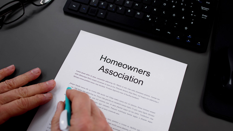 Hands holding a pen signing an HOA agreement
