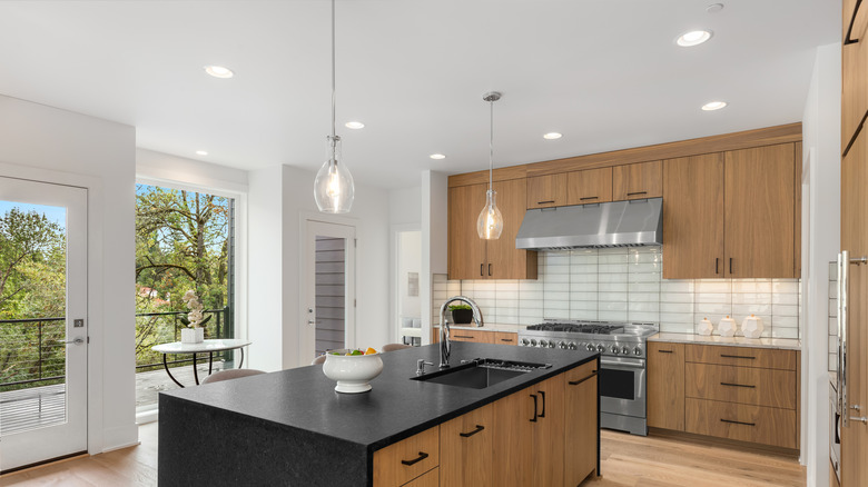A large kitchen with oak cabinets and a freestanding butcher's block with sink in black granite.