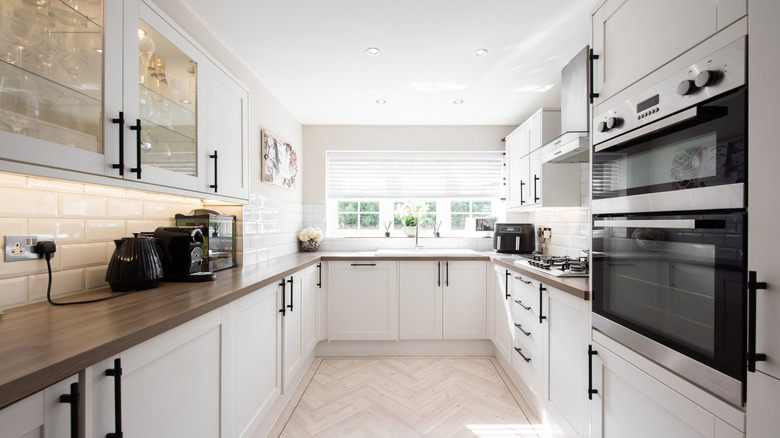 Large kitchen with dark vinyl countertops and white cabinets