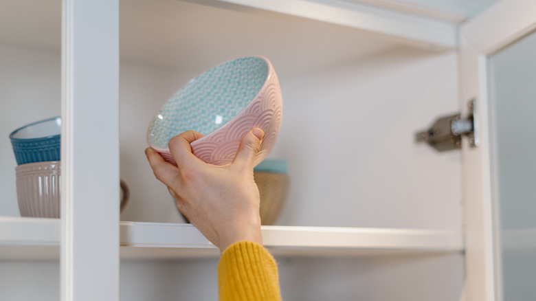 person putting away a bowl