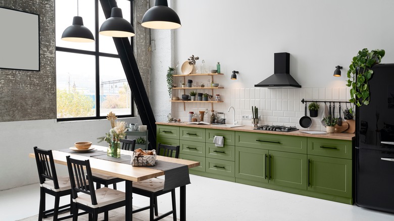 Green kitchen cabinets on white walls