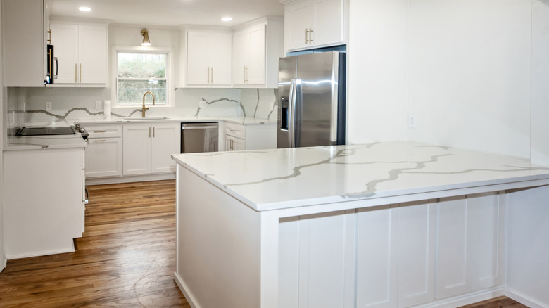 kitchen with white and gray quartz countertops and backsplash