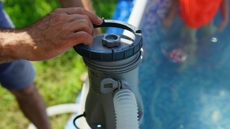A person changing a pool filter