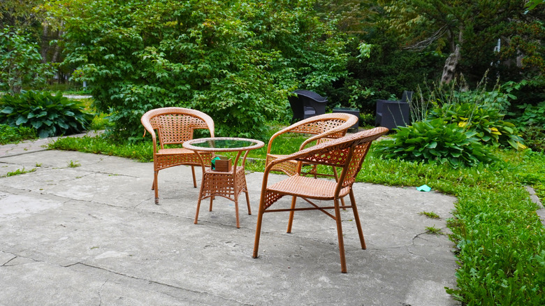 Wicker dining set on damaged concrete patio