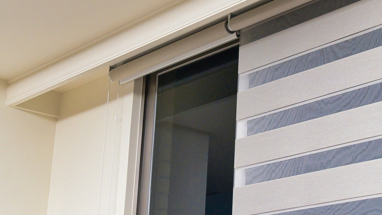 Zebra shades hanging over window, one opened and another partially opened