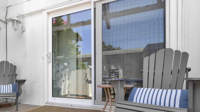 A front porch with two chairs and a sliding glass door