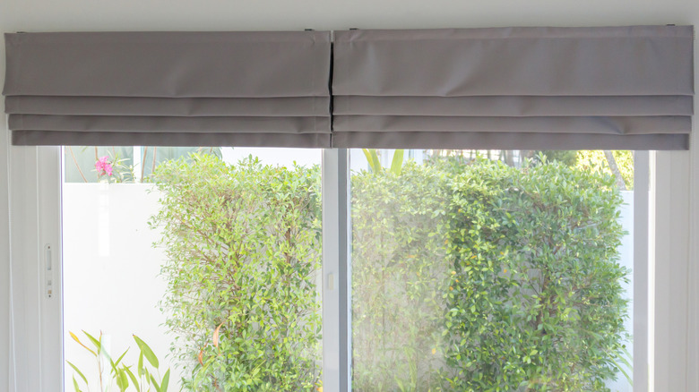 Linen Roman shades pulled up on sliding glass doors