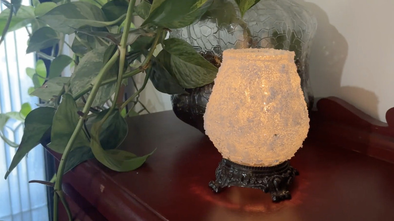 A glass candle holder covered in Epsom salt.