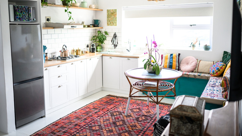 Red patterned rug in a bright, modern kitchen with white cabinets