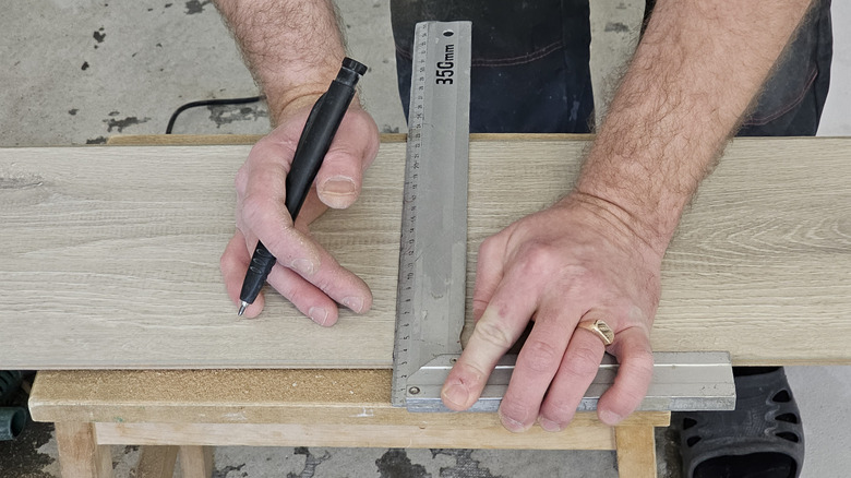 Carpenter marking wood with a square tool