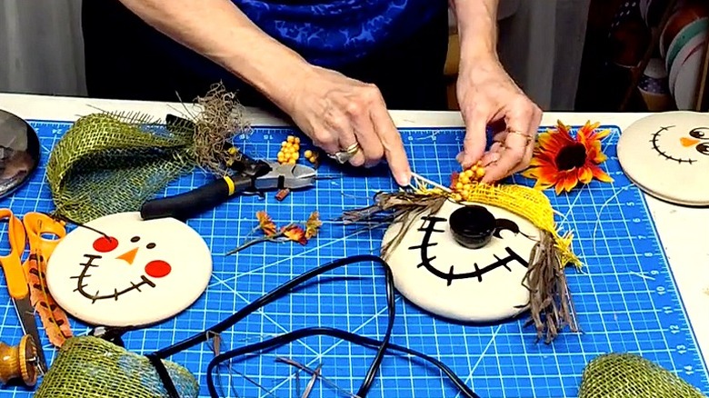 Split image of DIY scarecrow faces made from casserole pot lids in progress
