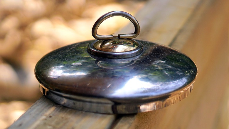 Close-up of a small stainless steel pot lid with a ring holder