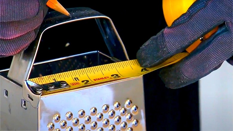 person measuring cheese grater