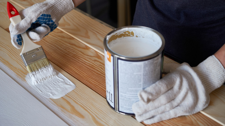 Person painting wood white