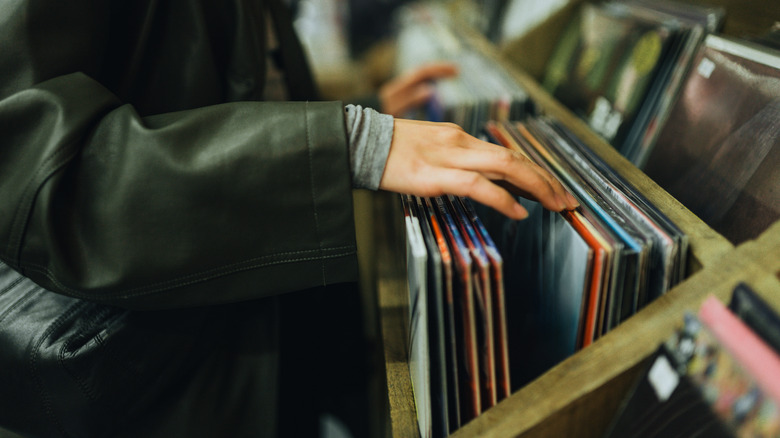 A person looking through vinyl records at a record store.