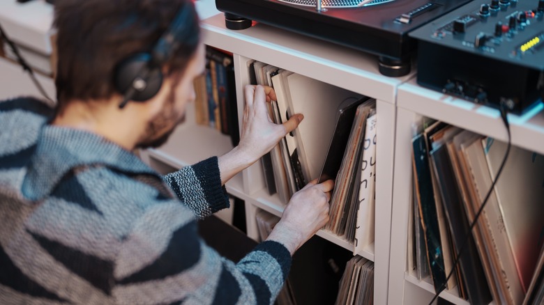 A man selecting a vinyl record from his collection.