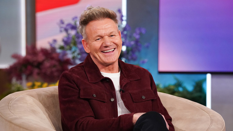 Gordon Ramsay smiling and sitting in chair on talk show