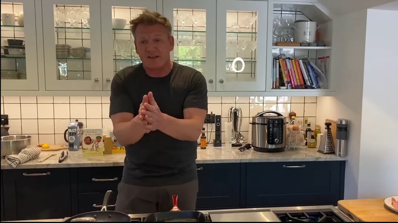 Gordon Ramsay in LA kitchen with glass-front cabinets in background