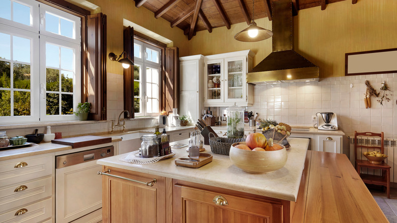 A rustic modern farmhouse kitchen with timber cabinets, large island, and gold-toned hardware