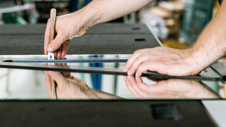 person cutting a mirror