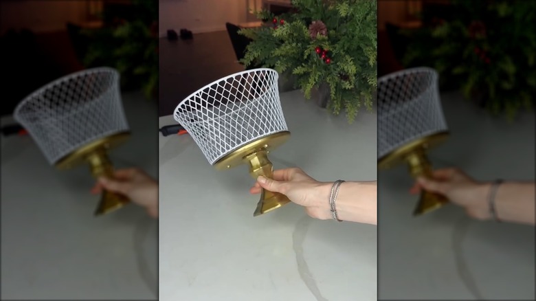 A closeup of a hand holding the finished pedestal fruit bowl