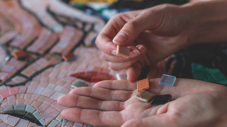 hand holding small tile pieces