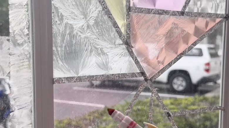 DIY stained glass window with hand holding marker