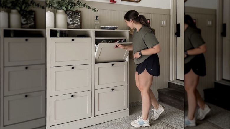 A woman opens the drawer of a large storage system made from IKEA BRUSALI shoe cabinets.