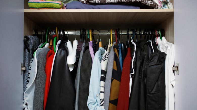 Small closet packed with clothes
