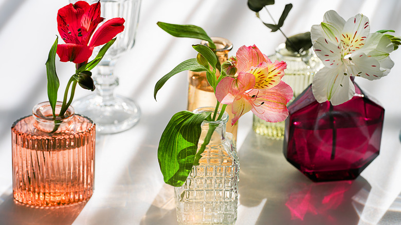 Different flowers in perfume-sized vases