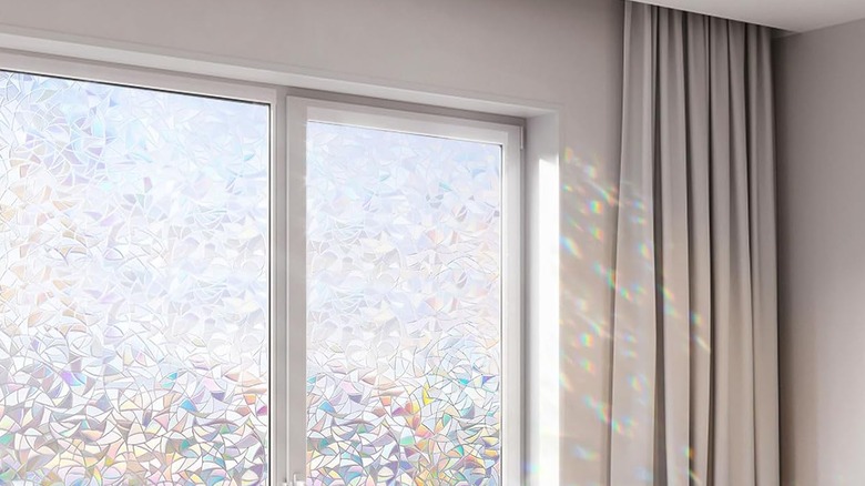 Patterned prismatic window film creating rainbow dots on the wall and curtain