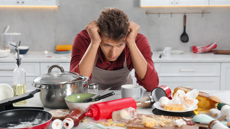 upset man in messy kitchen