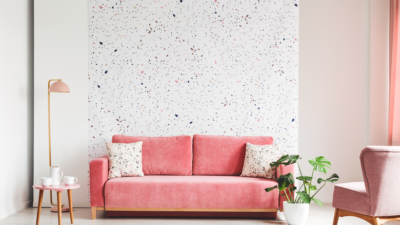 pink couch on spotted wall