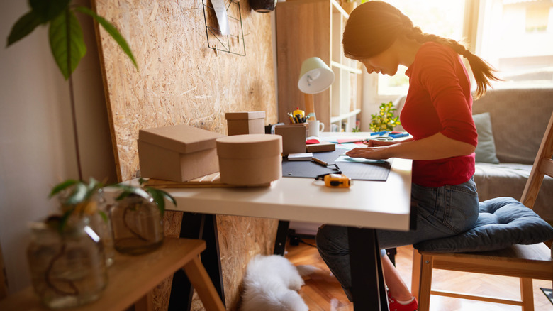 Someone working on a DIY in her craft room