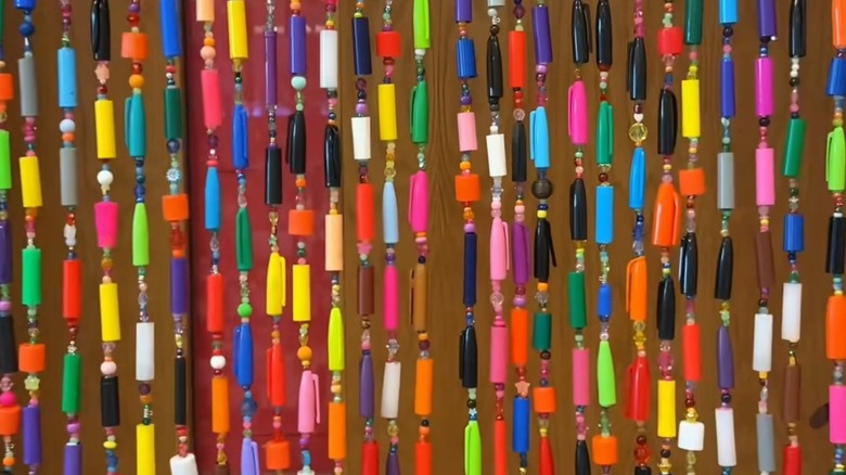The beaded curtain made of marker caps.