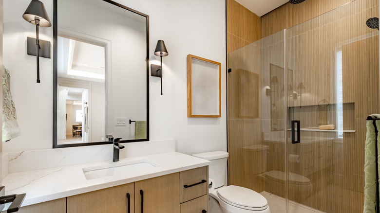 Modern bathroom with black mirror and wall lights