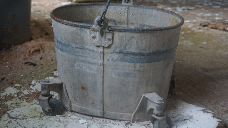 An old galvanized steel mop bucket with wheels.