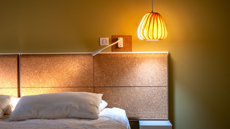 bed with a hanging warm accent lamp