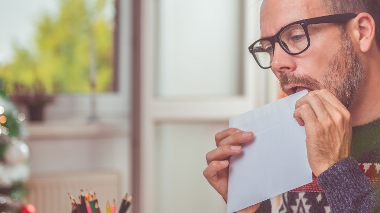 Man licking envelope