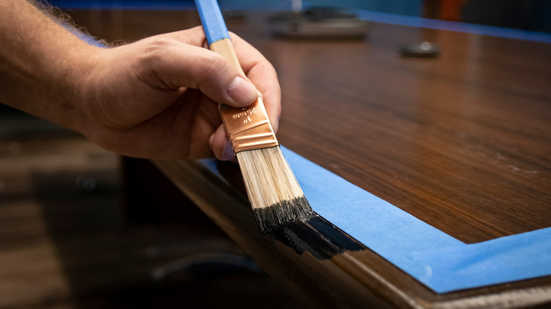 person refinishing desk