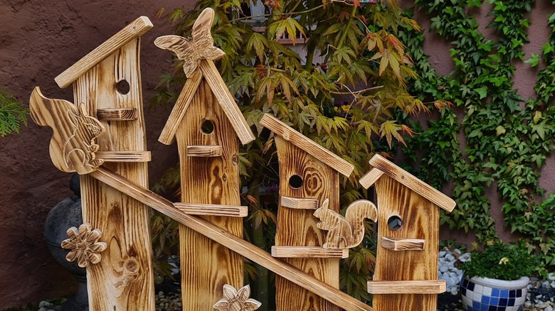 A wooden craft with bird perches and animal cut-outs.