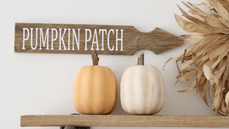 A wooden garden sign pointing to a pumpkin patch.