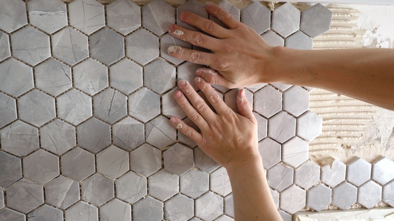 person installing tile