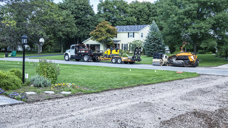 A driveway in the middle of driveway renovations, with heavy machinery in the background to help with the redesign