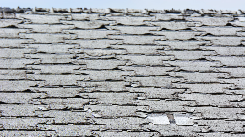 Old roof with curled and missing shingles
