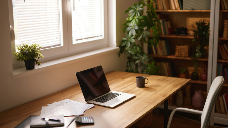 A home office with a desk in front of a window