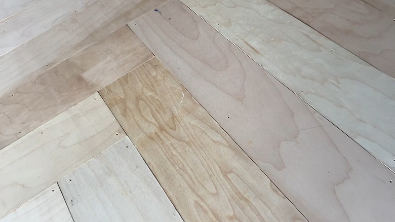 A close up photo of a newly made herringbone pattern wood pantry door.