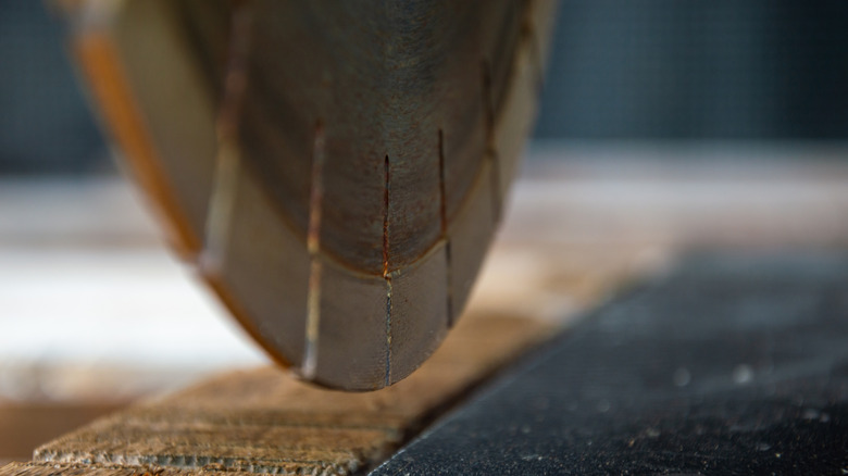 Circular saw blade moving close to a piece of wood