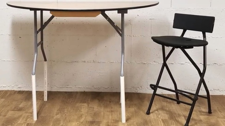 Folding table with PVC leg extensions to match height of folding chair
